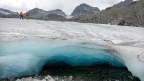Les glaciologues Andrea Fischer et Violeta Lauria de l'Académie autrichienne des sciences marchent sur le glacier Jamtal dans le Tyrol, en Autriche (juillet 2022).