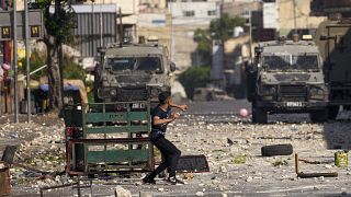 متظاهر فلسطيني يحرق الإطارات خلال مواجهات مع الجيش الإسرائيلي أثناء قيام القوات بعملية في مدينة نابلس بالضفة الغربية، 9 أغسطس 2022