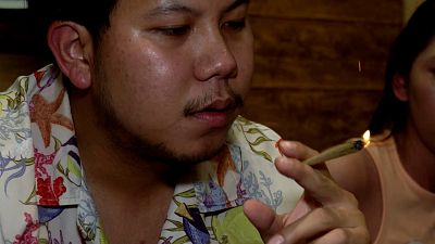 A customer smokes a joint in a new Bangkok cannabis smoking room