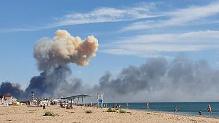 El humo creciente se puede ver desde la playa de Saky después de que se escucharan explosiones desde la dirección de una base aérea militar rusa cerca de Novofedorivka, Crimea