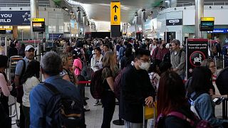 Travellers queue at security at Heathrow Airport in London, June 22, 2022. 