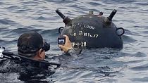 Buzo de la marina rumana sacando una foto de una mina flotante
