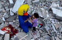 Переодетый в утёнка слен группы, оказывающей психологическую помощь палестинским детям, играет с ребёнком.