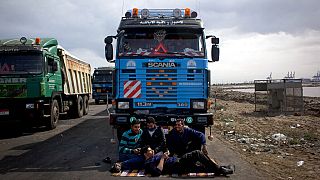 سائقو الشاحنات المصريون يجلسون بجانب سياراتهم بينما قام المتظاهرون بإغلاق الطريق المؤدي إلى الميناء الشرقي لمنع الشاحنات المحملة من مغادرة الميناء، في بورسعيد، 22 فبراير 2013