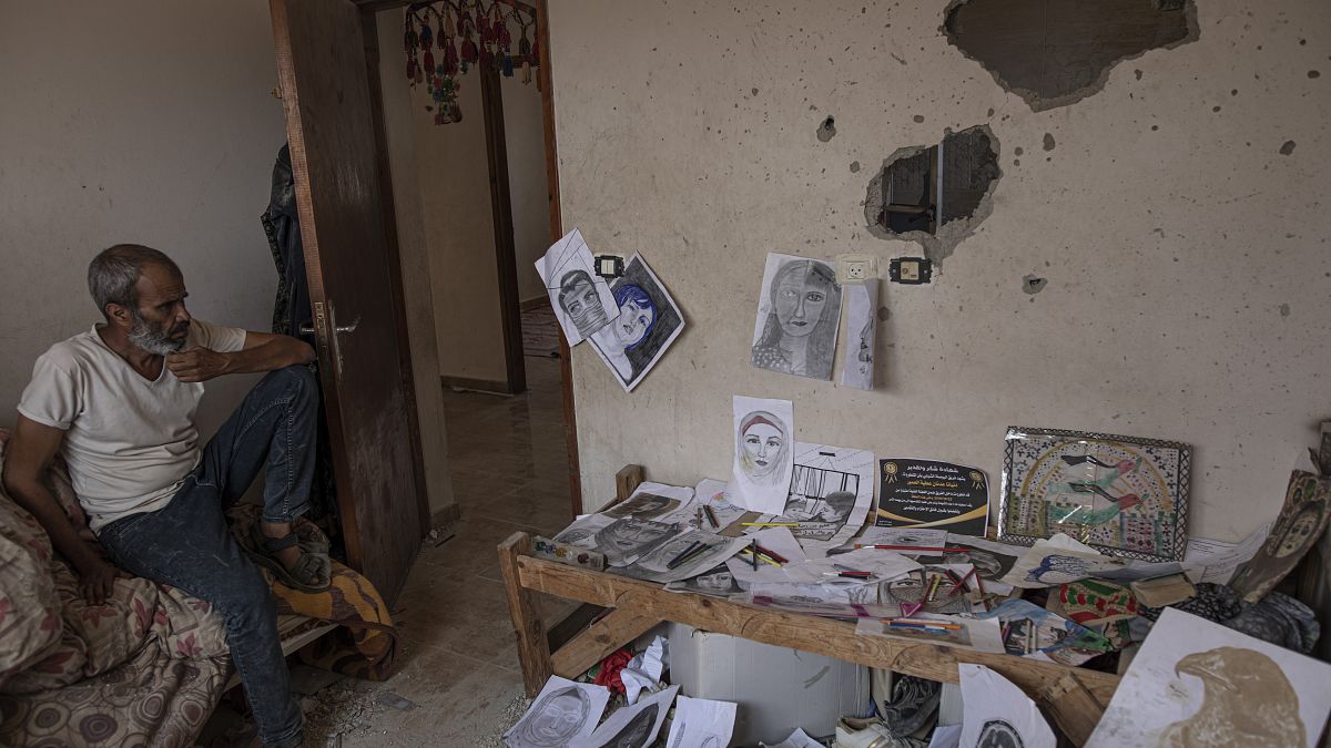 داخل غرفتها ـ مرسمها، يجلس عدنان والد الرسّامة الفلسطينية الشابة دنيانا العمور التي قتلت في منزلها بخانيونس بقذيفة إسرائيلية، 5أغسطس 2022.