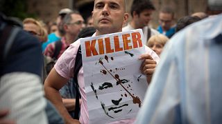 A protester holds a poster depicting Russia's President Putin along with sign "Killer" during a protest rally in downtown Sofia, 10 August 2022
