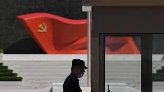 ضابط أمن يقف بالقرب من تمثال لعلم الحزب الشيوعي الصيني في متحف الحزب الشيوعي الصيني ببكين، 26 مايو 2022.