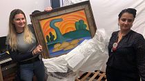 Officers show artist Tarsila do Amaral's painting titled "Sol Poente" after it was seized during a police operation in Rio de Janeiro