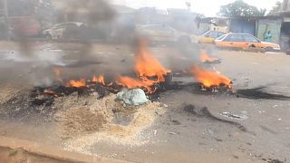 Burned tyres block a street during the protest in Freetown.