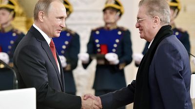 Mikhail Piotrovsky, direttore del Museo dell'Ermitage di San Pietroburgo, stringe la mano a Vladimir Putin