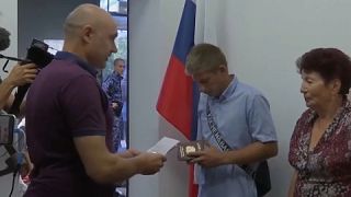 مواطنون أوكرانيون في دائرة الهجرة بمركز شرطة بيرديانسك يحصلون على جوازات سفر روسية، 12 أغسطس 2022.