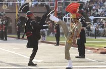 عناصر من أمن الحدود الهندية (زي بني) وحراس باكستانيون (زي أسود) يشاركون في مراسم حدود واجاه الهندية الباكستانية.