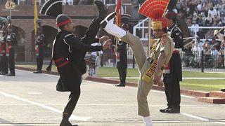 عناصر من أمن الحدود الهندية (زي بني) وحراس باكستانيون (زي أسود) يشاركون في مراسم حدود واجاه الهندية الباكستانية.
