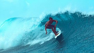 An extreme surfer rides a barrel wave in Teahupo'o