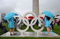 Hostessen und Besucher stehen neben den Olympischen Ringen anlässlich des 50. Jahrestages der Olympischen Sommerspiele 1972 in München
