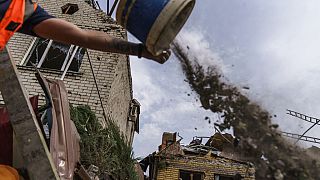 Um trabalhador limpa destroços dos bombardeamentos na região de Donetsk, no leste da Ucrânia