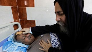 قس يتفقد أحد المصابين في حادث حريق كنيسة أبو سيفين بالمستشفى يوم الأحد