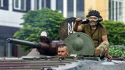 Ukrainian servicemen ride in a tank on a street in the Donetsk region, eastern Ukraine, Sunday, Aug. 14, 2022.