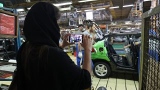 Egy újságíró fényképet készít az Iran Khodro gyárában 2022. augusztus 14-én.