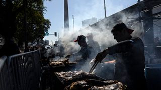 Parrilleros asan carne para la venta en un puesto durante un campeonato de asado en Buenos Aires, Argentina, el 14 de agosto de 2022.
