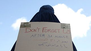 سيدة أفغانية ترتدي البرقع وتحمل لافتة مكتوب عليها لا تنسونا أمام السفارة الفرنسية في كابول، أفغانستان.
