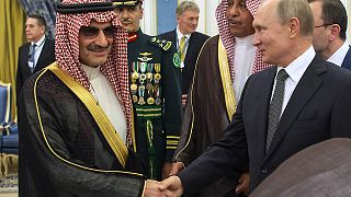 الرئيس الروسي فلاديمير بوتين يصافح الأمير السعودي وليد بن طلال بن عبد العزيز آل سعود في الرياض، المملكة العربية السعودية.