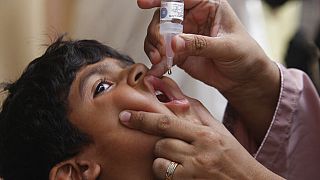 ممرض يعطي لقاح شلل الأطفال لطفل في كراتشي، باكستان، في 23 مايو/أيار 2022.