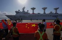 Les employés du port d'Hambantota tendent un gigantesque drapeau chinois sur les quais pour accueillir le navire chinois Yuan Wang 5 le 16 août 2022.
