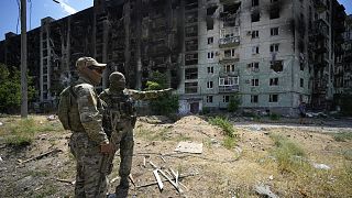 Orosz katonák egy szétrombolt szeverodonyecki épület mellett, Luhanszkban