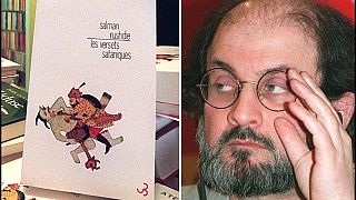 الكاتب البريطاني المولود في الهند سلمان رشدي خلال مؤتمر صحفي، في 16 فبراير 1996، في باريس، وعينة من النسخة الفرنسية من كتابه "آيات شيطانية".