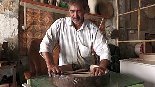 Un artisan irakien confectionne des tambourins traditionnels à la main