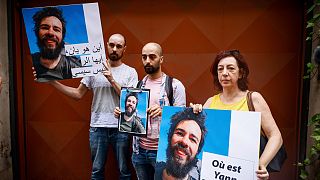 والدة الرحالة الذي كان مفقوداً في مصر يان بوردون ترفع صورة ابنها خلال اعتصام بالقرب من قصر الإليزيه خلال زيارة الرئيس المصري عبد الفتاح لفرنسا، 22 يوليو 2022.