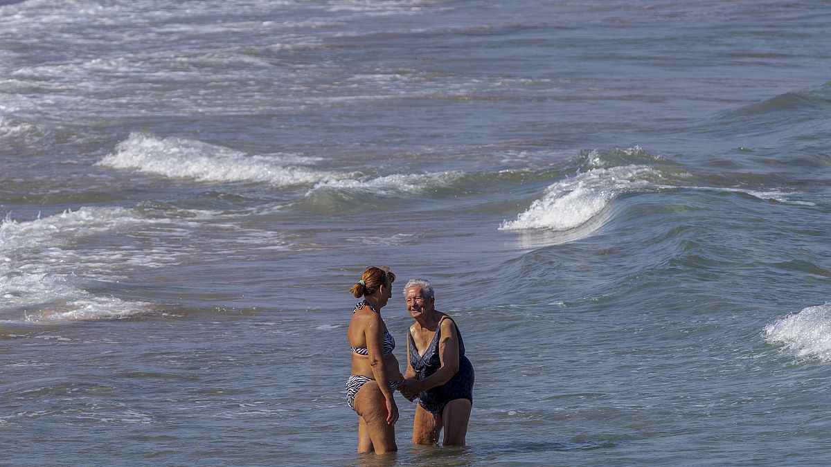 Zwei Frauen nehmen am Strand von Puerto de Sagunto ein Bad im Mittelmeer
