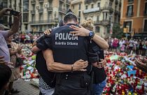 Photo d'archive du 21 aout 2017, quatre jours après l'attaque à Barcelone, un policier serre des personnes dans ses bras