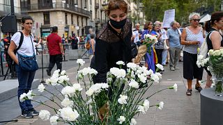 امرأة تضع زهرة في ذكرى هجوم برشلونة