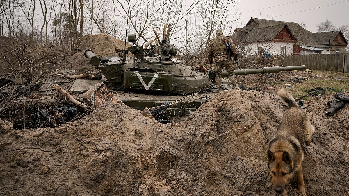 Украинский солдат на подбитом российском танке в селе Андреевка Киевской области (начало апреля 2022 г.)