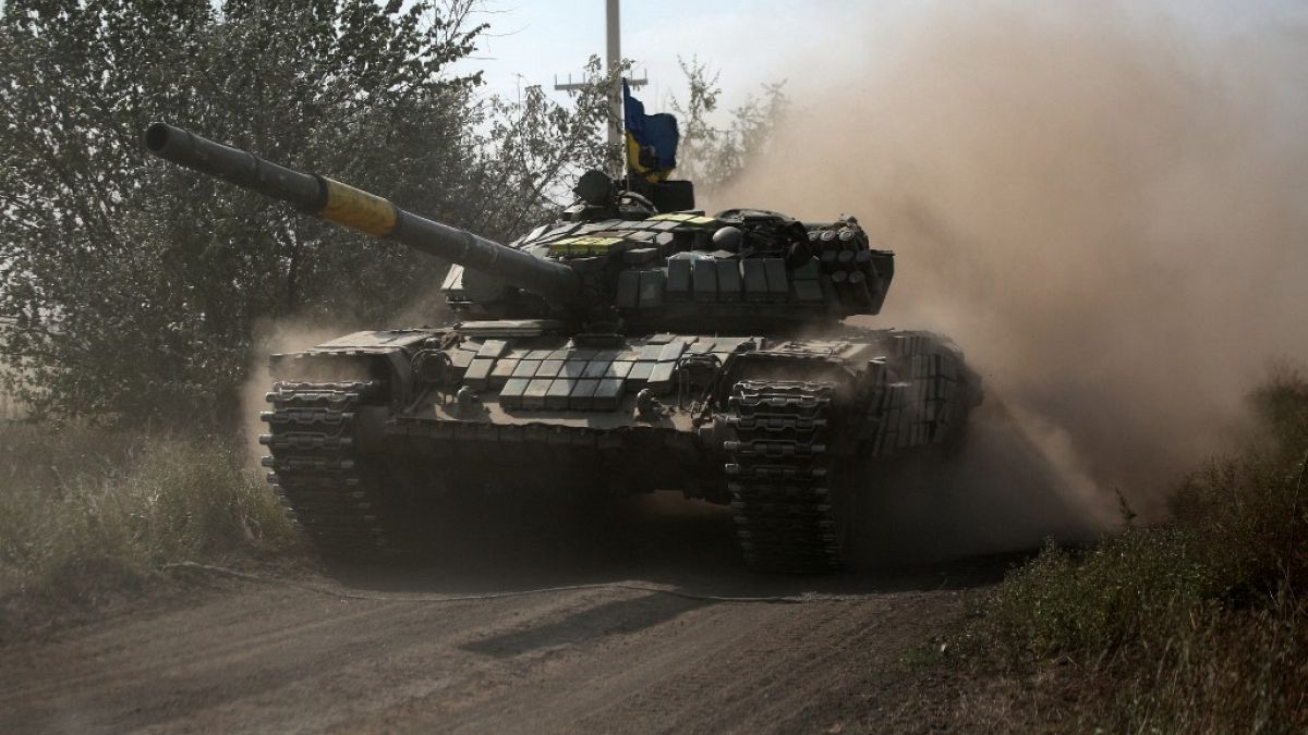 A Ukrainian tank rolls down a road at a position along the front line in the Donetsk region on August 15, 2022.
