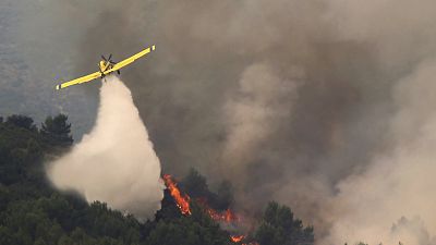 A firefighting plane drops water during fire extinguish works in Viver, eastern Spain, on Wednesday, Aug. 17, 2022.