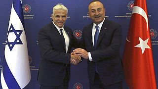Jair Lapid izraeli miniszterelnök (balra) és Mevlüt Cavusoglu török külügyminiszter kézfogása júniusi ankarai találkozásukon