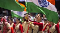 Assamese girls and boys in traditional attire carry Indian flags as they perform Bihu dance on Independence Day in Gauhati, northeastern Assam state, India, Aug. 15, 2022