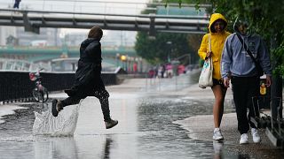 Gente corriendo bajo la lluvia en Londres tras semanas de clima sofocante, que ha provocado sequía y ha dejado la tierra reseca, el 17 de agosto de 2022.