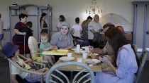 لاجئون أوكرانيون يتناولون الطعام في مخيم افتتح مؤخراً في المجر