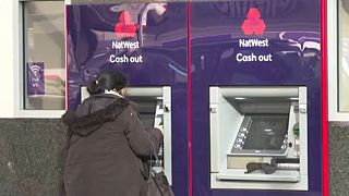 Egy ügyfél pénzt vesz ki a NatWest egyik automatájából