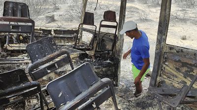 Сгоревший в результате лесного пожара автобус в регионе Эль-Тарф. 18 августа 2022.