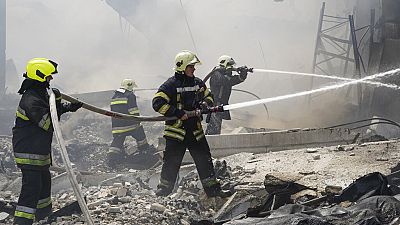 Украинские пожарные работают в разрушенных зданиях после ракетного обстрела минувшей ночью