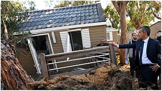 وزير الداخلية الفرنسي جيرالد دارمانين ينظر إلى منزل من طابق واحد متضرر في جزيرة كورسيكا