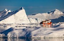قارب يحمل السياح بين الجبال الجليدية العائمة في خليج ديسكو، إيلوليسات، غرب غرينلاند، 1 يوليو 2022