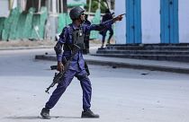 A security officer gestures as he and colleagues patrol at the the site of explosions in Mogadishu on August 20, 2022