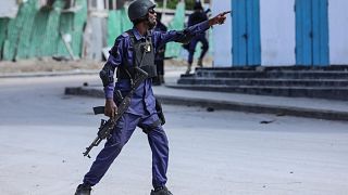 A security officer gestures as he and colleagues patrol at the the site of explosions in Mogadishu on August 20, 2022