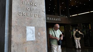 Egy férfi sétál ki a görög nemzeti bank épületéből